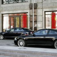 To luksusbiler foran fornem bygning