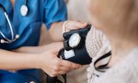 Kvindelig læge tjekker blodtryk på kvindelig patient