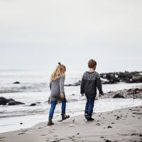 Bror og søster går på en strand